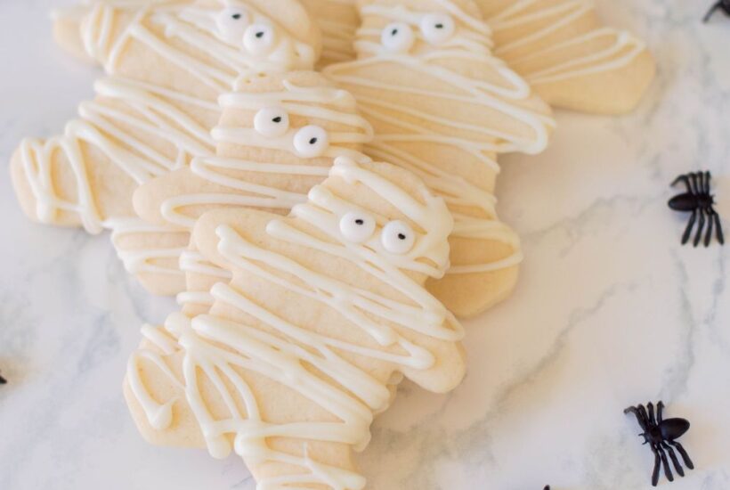 mummy sugar cookies with spiders on marble table