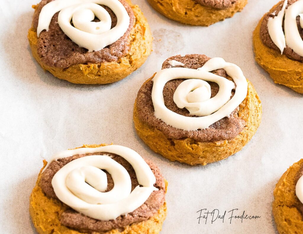 crumbl pumpkin roll cookies cooling on paper