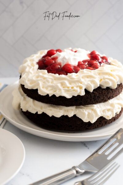 layered black forest cake whole with spatula