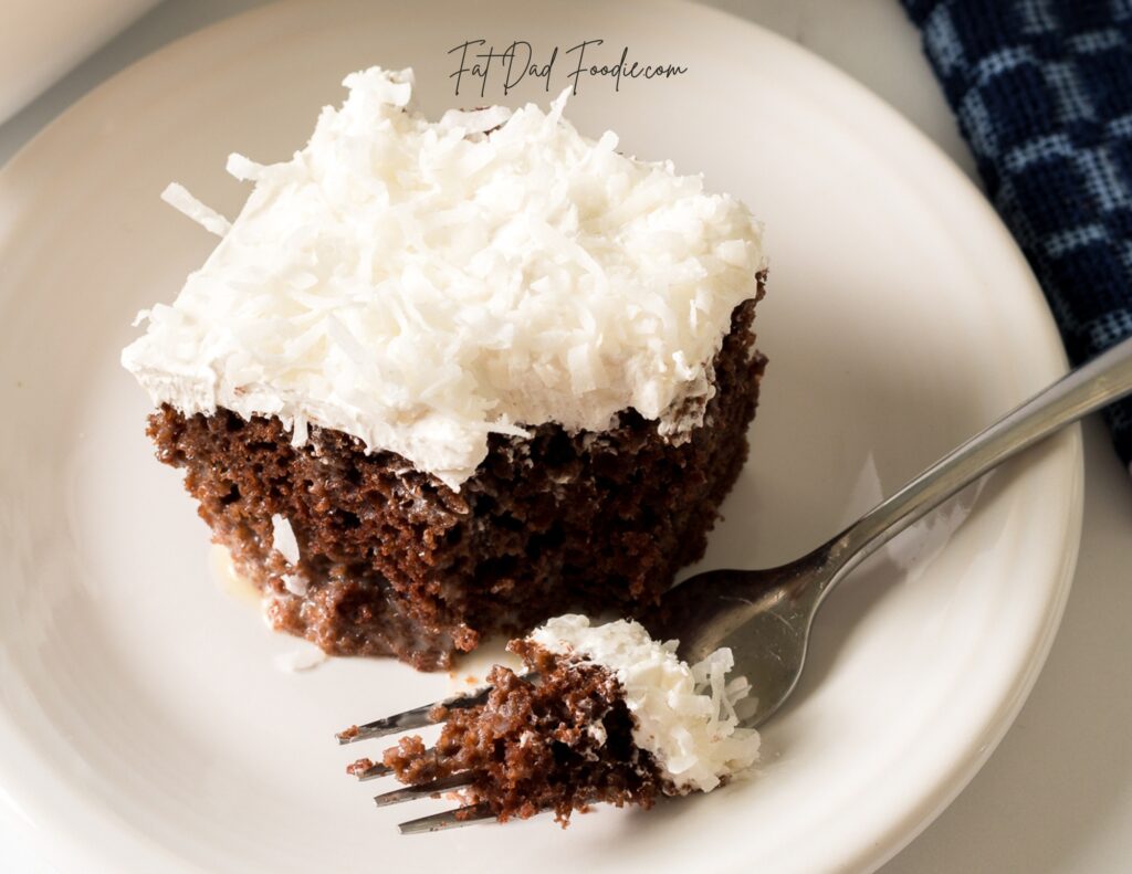 chocolate coconut poke cake piece on plate with fork