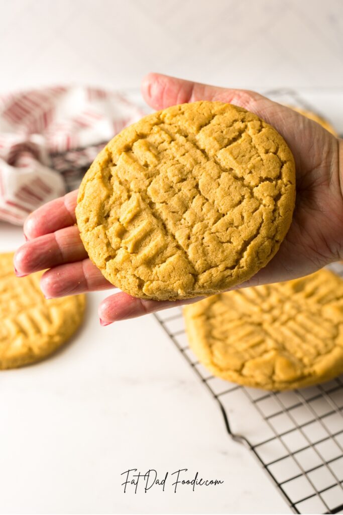 crumbl classic peanut butter cookies holding in hand